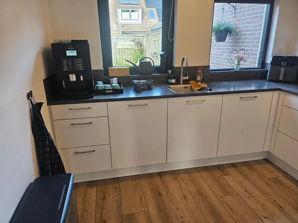 Keuken vóór het wrappen: witte keukenkastjes met raam